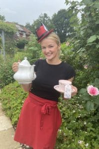 A photo of a lady holding a teapot and teacup