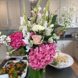 a photo of buffet food and a vase of flowers